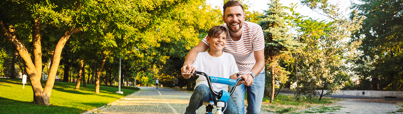 Father teaching son how to ride a bike