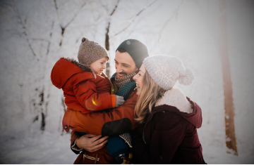 Family Smiling at Each Other In a Snowy Landscape