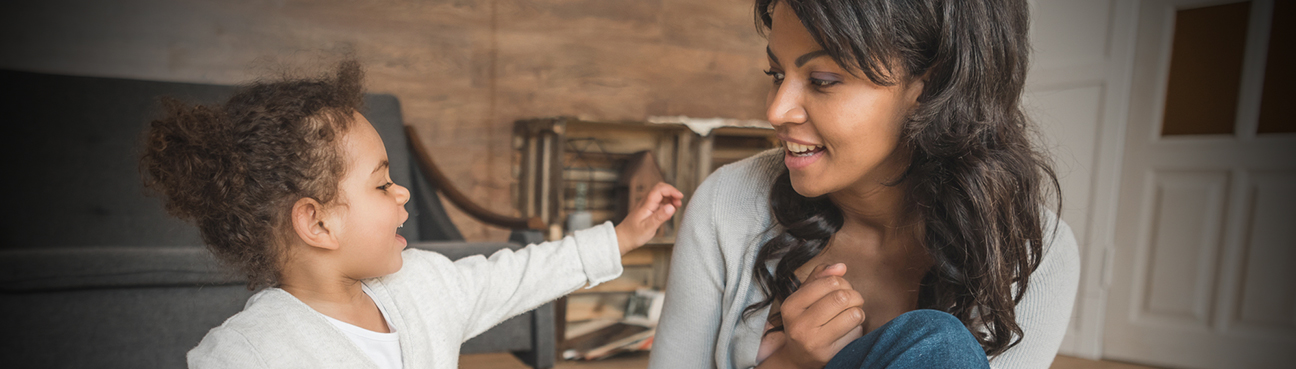 Young daughter reaching out to smiling mother